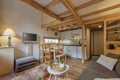 a living room with a table and a kitchen at Roca Cosy Duplex Grands Montets Parking Transports in Chamonix-Mont-Blanc