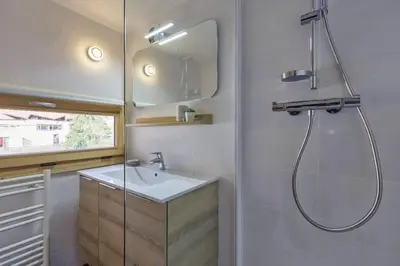 a bathroom with a sink and a shower with a mirror at Roca Cosy Duplex Grands Montets Parking Transports in Chamonix-Mont-Blanc