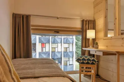 a bedroom with a bed and a large window at Roca Cosy Duplex Grands Montets Parking Transports in Chamonix-Mont-Blanc