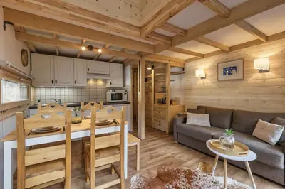 a kitchen and living room with a couch and a table at Roca Cosy Duplex Grands Montets Parking Transports in Chamonix-Mont-Blanc