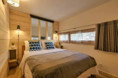 a bedroom with a large bed with blue and white pillows at Roca Cosy Duplex Grands Montets Parking Transports in Chamonix-Mont-Blanc