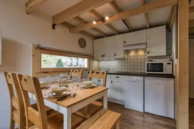 a kitchen with a table and chairs in a kitchen at Roca Cosy Duplex Grands Montets Parking Transports in Chamonix-Mont-Blanc