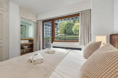 a bedroom with towels on a bed with a window at Bios Moderne 3CH Vue Mt Blanc Aiguilles 3mn Brevent in Chamonix-Mont-Blanc