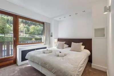 a bedroom with a large bed and a large window at Bios Moderne 3CH Vue Mt Blanc Aiguilles 3mn Brevent in Chamonix-Mont-Blanc