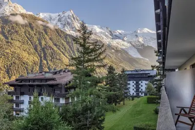 a building with a tree in front of a mountain at Bios Moderne 3CH Vue Mt Blanc Aiguilles 3mn Brevent in Chamonix-Mont-Blanc