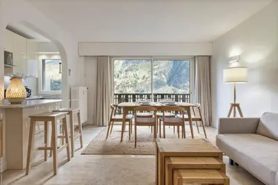 a kitchen and living room with a table and chairs at Bios Moderne 3CH Vue Mt Blanc Aiguilles 3mn Brevent in Chamonix-Mont-Blanc