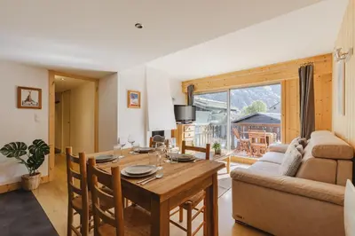 a living room with a table and a couch at Savoy Cosy 1CH pied pistes Hypercentre Vue MtBlanc in Chamonix-Mont-Blanc