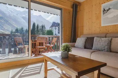 a living room with a couch and a table at Savoy Cosy 1CH pied pistes Hypercentre Vue MtBlanc in Chamonix-Mont-Blanc