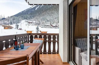 a table on a balcony with a view of a ski slope at Savoy Cosy 1CH pied pistes Hypercentre Vue MtBlanc in Chamonix-Mont-Blanc