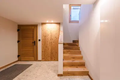 a hallway with a wooden door and stairs at Luxury Chalet with Private Spa & Wellness Area in Megève