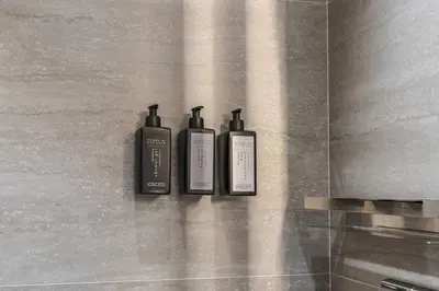 three shampoo bottles sitting on a wall in a bathroom at Luxury Chalet with Private Spa & Wellness Area in Megève
