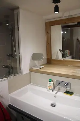 a bathroom with a sink and a mirror at La CHACUNIERE GRAND CHALET ST NICOLAS DE VEROCE, PRES DES PISTES in La Chapelle