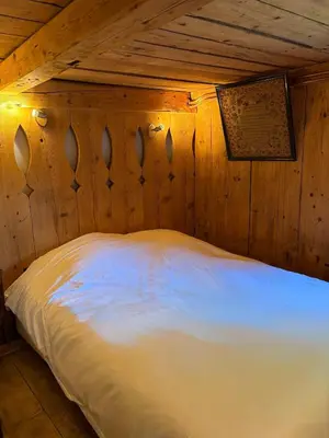 a bedroom with a bed in a wooden room at La CHACUNIERE GRAND CHALET ST NICOLAS DE VEROCE, PRES DES PISTES in La Chapelle
