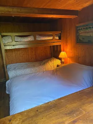 a bedroom with two beds in a cabin with a lamp at La CHACUNIERE GRAND CHALET ST NICOLAS DE VEROCE, PRES DES PISTES in La Chapelle