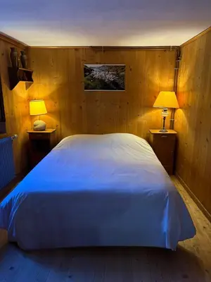 a bedroom with a large white bed with two lamps at La CHACUNIERE GRAND CHALET ST NICOLAS DE VEROCE, PRES DES PISTES in La Chapelle