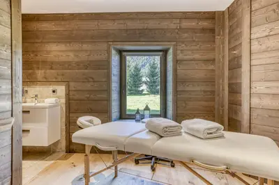 a spa room with a bench and a window at Chalet exceptionnel de 600m2 - Spa, salle de gym, ski-room in Samoëns