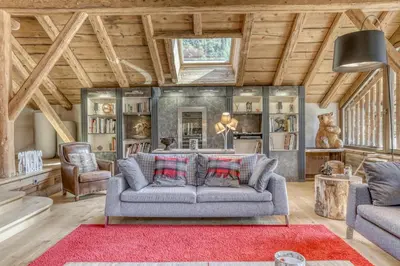 a living room with a gray couch and a red rug at Chalet exceptionnel de 600m2 - Spa, salle de gym, ski-room in Samoëns