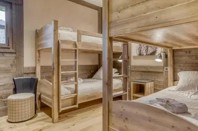 a bedroom with two bunk beds and a desk at Chalet exceptionnel de 600m2 - Spa, salle de gym, ski-room in Samoëns