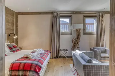 a bedroom with a bed and a couch and a chair at Chalet exceptionnel de 600m2 - Spa, salle de gym, ski-room in Samoëns