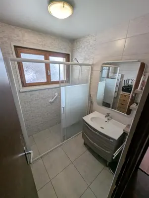 a bathroom with a shower and a sink and a mirror at Chez Math et Lolo in Sallanches