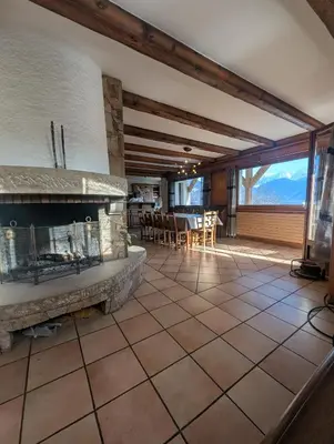 a living room with a fireplace and a table and chairs at Chez Math et Lolo in Sallanches