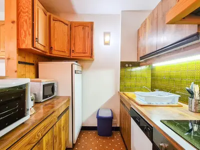 a kitchen with wooden cabinets and a white refrigerator at Studio spacieux au pied des pistes avec terrasse et WIFI - FR-1-425-239 in Arâches-la-Frasse