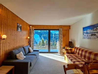a living room with a couch and a large window at Studio spacieux au pied des pistes avec terrasse et WIFI - FR-1-425-239 in Arâches-la-Frasse