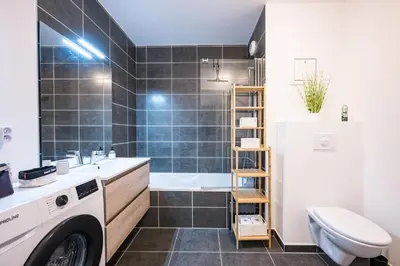 a bathroom with a sink and a washing machine at Capucines des Alpes - Au pied du Mont Blanc in Saint-Gervais-les-Bains