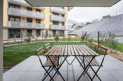 a picnic table and two benches in front of a building at Capucines des Alpes - Au pied du Mont Blanc in Saint-Gervais-les-Bains