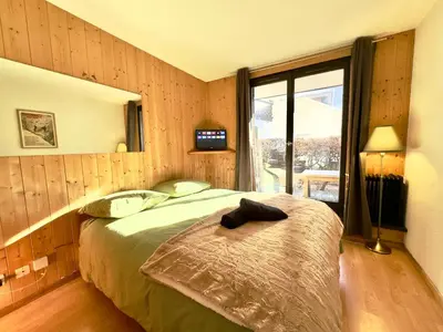 a bedroom with a bed in a room with a window at Chamonix studio vue Montblanc et parking in Chamonix-Mont-Blanc