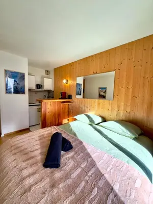 a bedroom with a large bed with a hat on it at Chamonix studio vue Montblanc et parking in Chamonix-Mont-Blanc