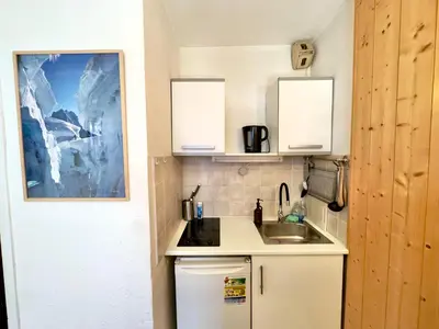a small kitchen with white cabinets and a sink at Chamonix studio vue Montblanc et parking in Chamonix-Mont-Blanc