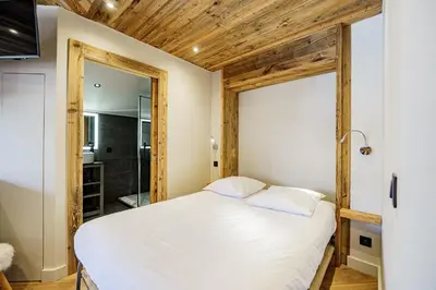 a bedroom with a bed and a mirror at Alpine Mood - Proche des pistes et Centre ville in Megève