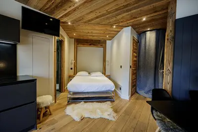a bedroom with a bed and a tv in a room at Alpine Mood - Proche des pistes et Centre ville in Megève