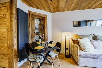 a dining room with a table and a couch at Alpine Mood - Proche des pistes et Centre ville in Megève