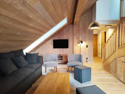 a living room with a couch and chairs and a tv at La Source in Saint-Gervais-les-Bains