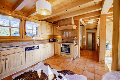 a large kitchen with wooden cabinets and a stove at Chalet Panorama in Combloux