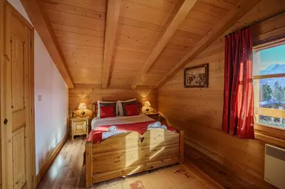 a bedroom with a bed in a log cabin at Chalet Panorama in Combloux