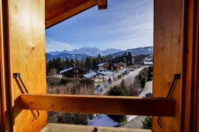 a window in a cabin with a view of the mountains at Chalet Panorama in Combloux