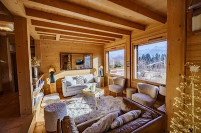a living room filled with furniture and a large window at Chalet Panorama in Combloux