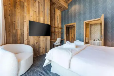 a bedroom with a bed and a tv on a wall at Observatoire Sompteux Loft 3CHBR Elegant Vues in Megève
