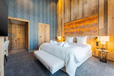 a bedroom with a large white bed and a television at Observatoire Sompteux Loft 3CHBR Elegant Vues in Megève