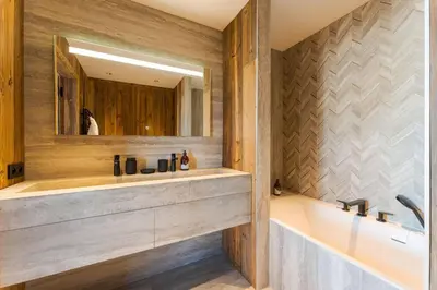 a bathroom with a tub and a sink and a mirror at Observatoire Sompteux Loft 3CHBR Elegant Vues in Megève
