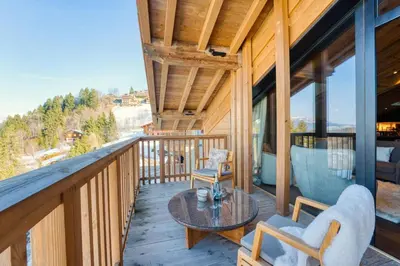 a balcony of a house with a table and chairs at Observatoire Sompteux Loft 3CHBR Elegant Vues in Megève