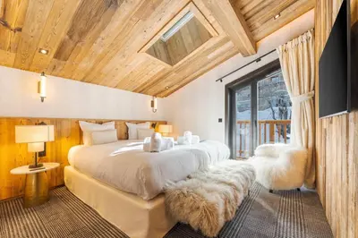 a bedroom with a large white bed with furry pillows at Observatoire Sompteux Loft 3CHBR Elegant Vues in Megève