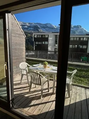 a patio with a table and chairs on a deck at Pied des pistes, piscine, jacuzzi in Flaine