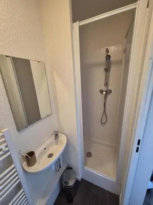 a bathroom with a sink and a shower with a mirror at Pied des pistes, piscine, jacuzzi in Flaine