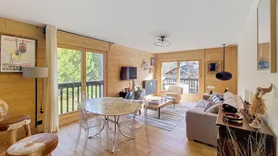 a living room with a table and a couch at 1 Riante Colline Arnica - PROCHE CENTRE in Megève