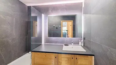 a bathroom with a sink and a mirror and a tub at 1 Riante Colline Arnica - PROCHE CENTRE in Megève