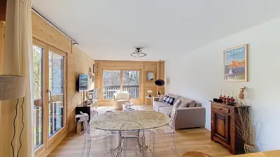 a living room with a table and a couch at 1 Riante Colline Arnica - PROCHE CENTRE in Megève